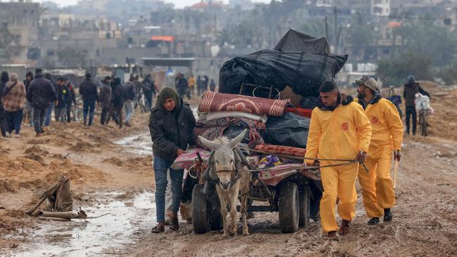 Palestinians, some wearing Hazmat suits left over from the Coronavirus pandemic to keep warm, transport their belongings as they flee Khan Younis in the southern Gaza Strip, on February 2, 2024. Picture: AFP