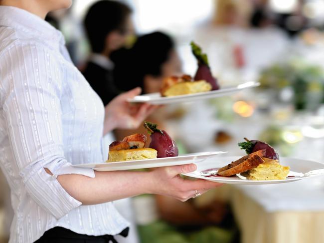 Waitress carrying three plates with meat dishGeneric photo of woman working in hospitality industry