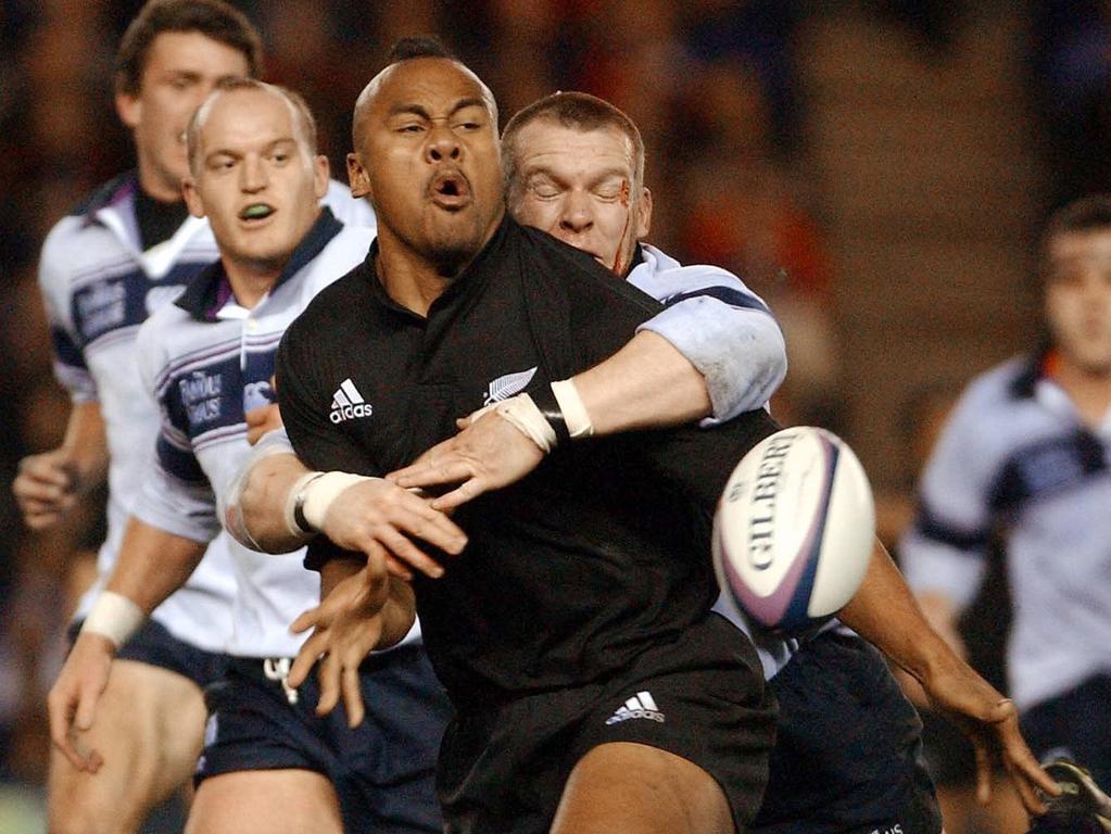 Jonah Lomu is tackled by Scotland’s James Mclaren as Gregor Townsend (L) looks on at Murrayfield Stadium,