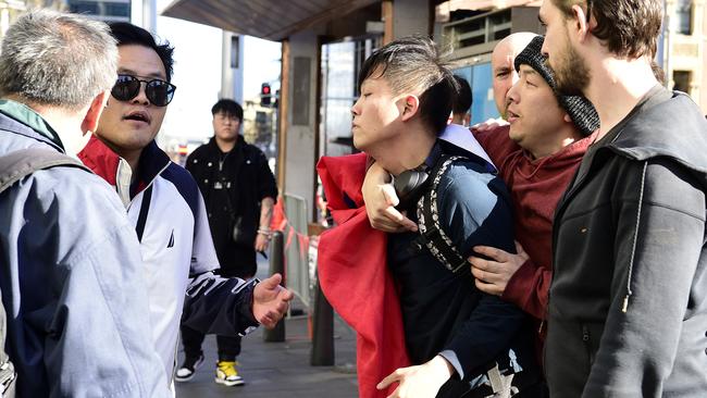 A pro-democracy supporter, centre, holding a Taiwanese flag clashes with pro-China supporters near Town Hall in Sydney. Picture: AAP