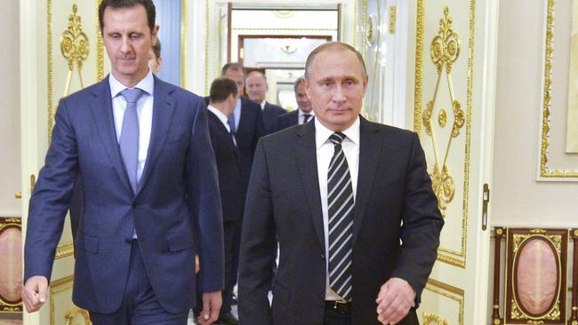 Vladimir Putin (R) and Bashar Assad enter a hall during a meeting at the Kremlin in Moscow.