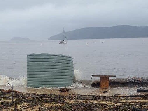 A rainwater tank and a large wooden cable wheel were among a lot of debris washed up at Patonga following widespread flooding. Picture: Facebook