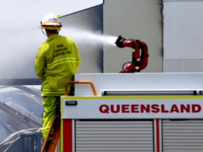 BRISBANE, AUSTRALIA - NewsWire Photos - DECEMBER 17, 2020.A fire truck douses with water the burnt remains of a recycling warehouse which was engulfed by massive blaze yesterday, at Hemmant in Brisbane's east.Picture: NCA NewsWire / Dan Peled