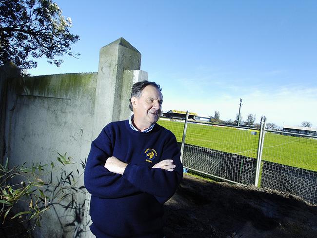 Legendary administrator John Mennie next to the wall at the Trevor Barker Beach Oval. Picture: Jason Sammon