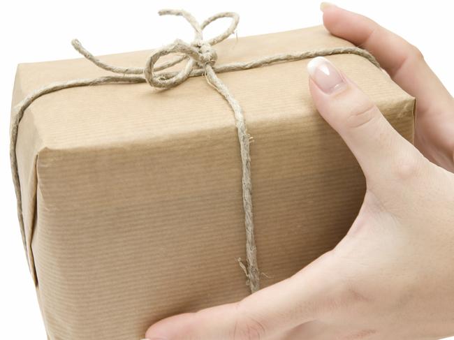 Female hands holding a brown parcel. Isolated on a white background.