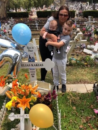 Elizabeth Kakias with baby Alexander and son Romeo at Elias's grave.