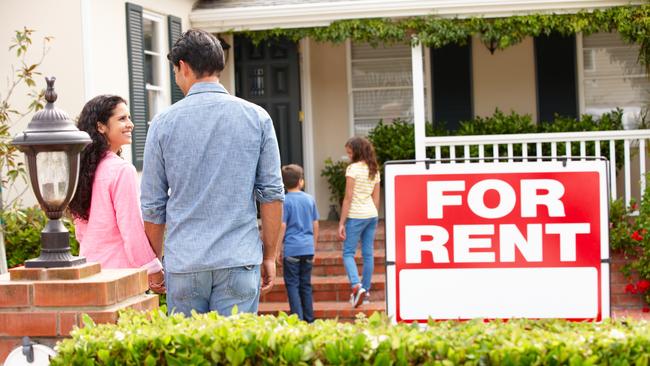 Hispanic family outside home for rent holding hands looking at each other happy