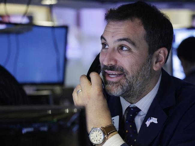 A trader smiles as he follows prices before the opening bell at the New York Stock Exchange, Friday, Jan. 22, 2016. (AP Photo/Mark Lennihan)