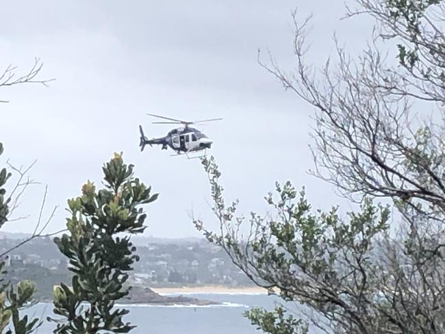 NSW Police helicopter searches near Blue Fish Point, near Manly, on Thursday. Picture: Jim O’Rourke