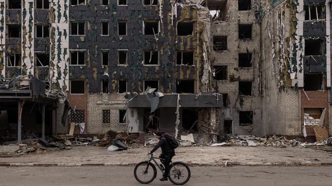 A cyclist rides past the destroyed Drujba hotel in Pokrovsk, Ukraine. President Volodymyr Zelensky said the area around Pokrovsk was "the most challenging right now" and added that "the military command and brigade command is working on strengthening positions”. Picture: Getty Images