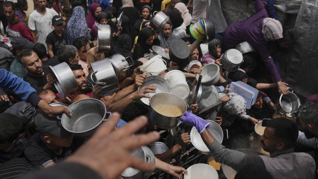 Palestinians struggle to get donated food at a community kitchen in Jabalia, northern Gaza Strip on Thursday. Picture: AP /Jehad Alshrafi