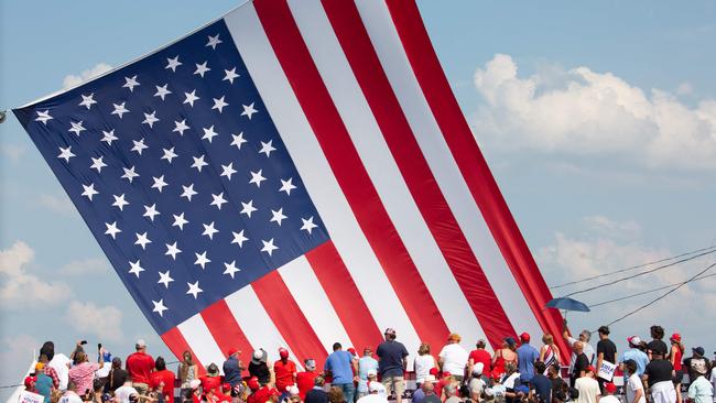 Trump supporters cheer as a giant American flag is untangled before Donald Trump speaks at Butler Farm Show. Picture: Rebecca Droke / AFP