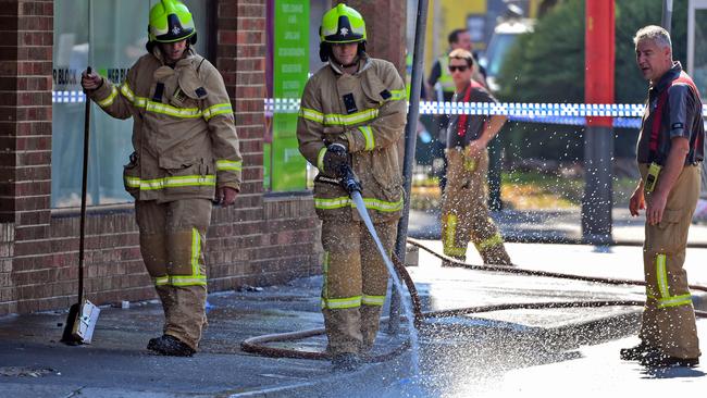 Firemen wash away bloodstains following the shooting. Picture: William West/AFP