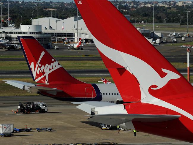 A Qantas (R) and a Virgin (L) plane sit on the tarmac at the international airport in Sydney on June 21, 2011. Thousands of passengers were grounded on June 21 as the Chilean ash cloud returned to Australia. The cloud, created by the eruption of the Puyehue volcano high in the Andes more than two weeks ago, has looped the globe and made its way back Down Under to wreak fresh havoc. AFP PHOTO / Greg WOOD