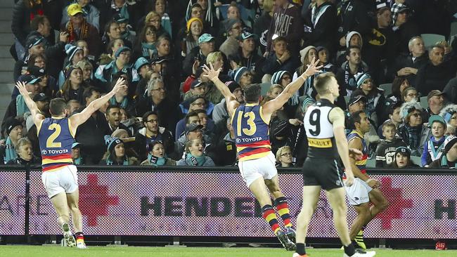 Brad Crouch and Taylor Walker run towards Eddie Betts as he kicked the last goal. Picture: Sarah Reed.