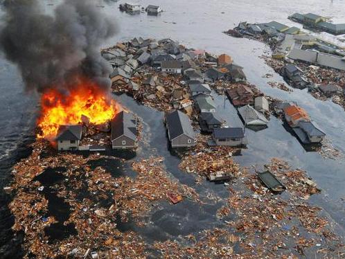 Houses swallowed by tsunami waves burn in Natori, Miyagi Prefecture (state) after Japan was struck by a strong earthquake off its northeastern coast Friday, March 11, 2011. (AP Photo/Kyodo News) MANDATORY CREDIT, NO LICENSING ALLOWED IN CHINA, HONG KONG, JAPAN, SOUTH KOREA AND FRANCE