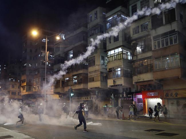 Protesters react to tear gas from Shum Shui Po police station in Hong Kong. Picture: AP