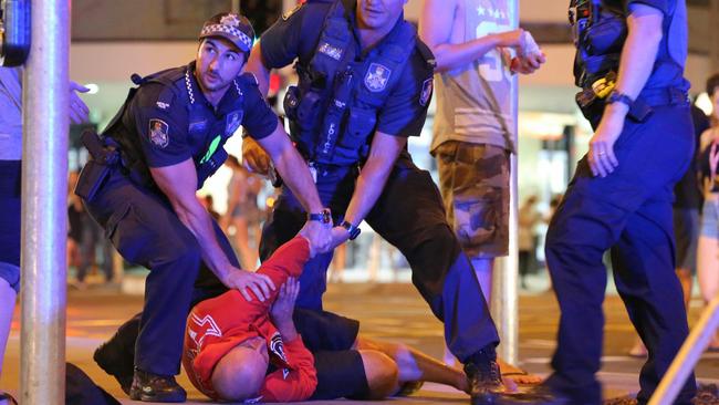 Police detain a man on Surfers Paradise Boulevard during Schoolies celebrations on the Gold Coast. Picture Glenn Hampson