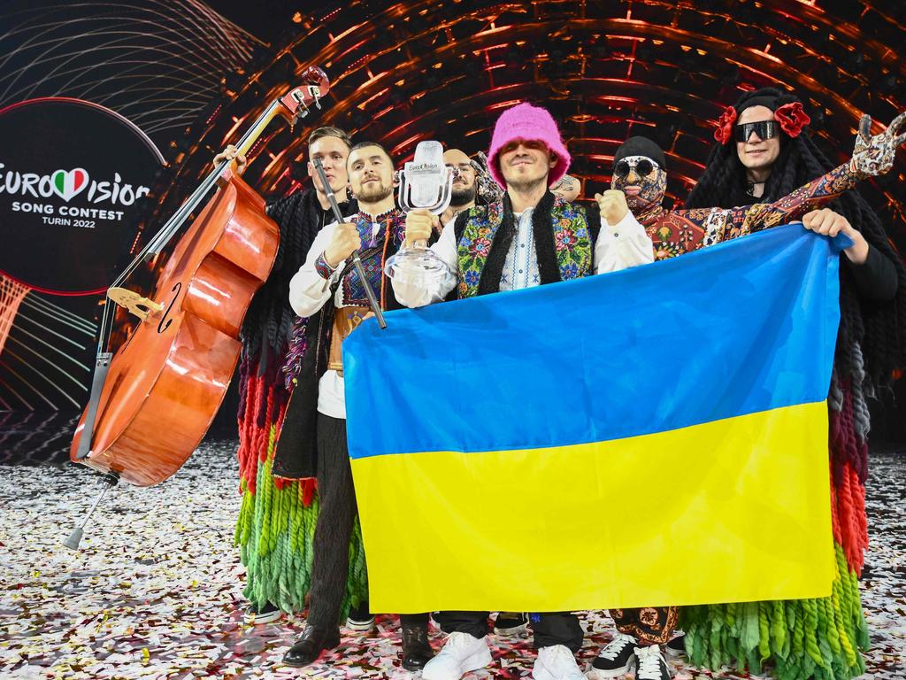 Members of the band Kalush Orchestra pose onstage with the winner's trophy and Ukraine's flags. Picture: Marco Bertorello / AFP.