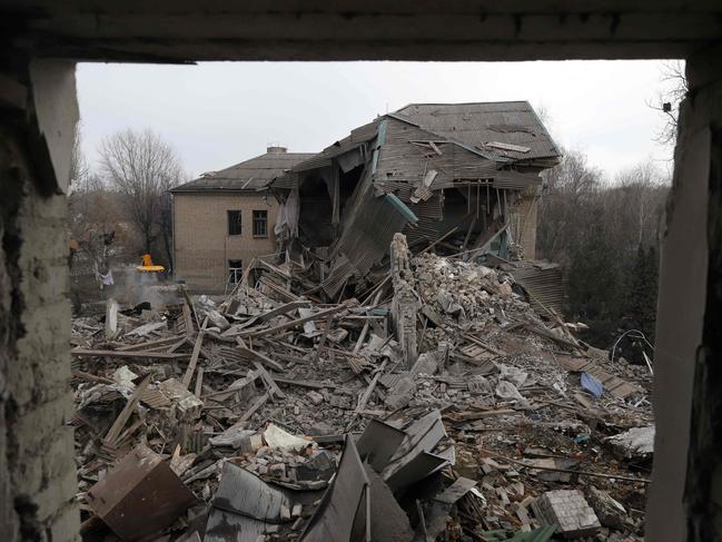 TOPSHOT - Rescuers clear debris of the destroyed two-storey maternity building in the town of Vilnyansk, southern Zaporizhzhia region, on November 23, 2022, amid the Russian invasion of Ukraine. - "As a result of a rocket attack on the territory of the local hospital, the two-storey building of the maternity ward was destroyed," they said in a statement. There was "a woman with a newborn baby as well as a doctor" inside the building at the time, they added. The baby died while the woman and doctor were rescued from the rubble, rescuers said. (Photo by Katerina Klochko / AFP)