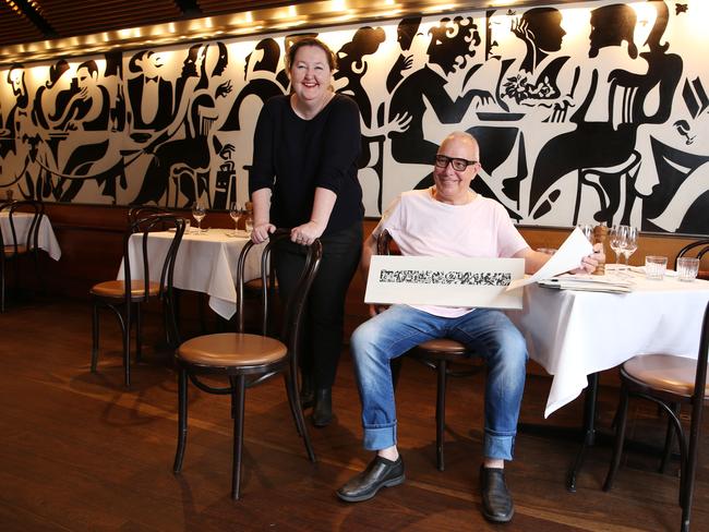 02/12/2020. Chef Damien Pignolet, former head chef of Moncur and Powerhouse CEO Lisa Havilah photographed at Bistro Moncur in Woollahra in Sydney's East, with the mural from Moncur and the mural miniature which marked the 10 year anniversary of the restaurant by Sydney artist Michael Fitzjames and will be included in the Pignolet collection as part of the archive. The Powerhouse is announcing the Powerhouse Museum's Culinary Archive , the first nationwide archive to collect the histories of the Australian food industry including restaurants, like Bistro Moncur, chefs, writers, producers and restaurateurs. Britta Campion / The Australian