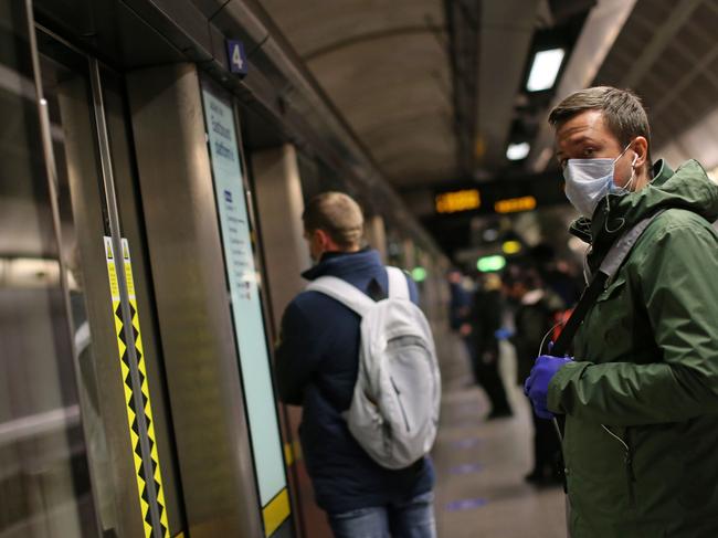 Londoners wait for the Tube wearing protective gear. Picture: AFP