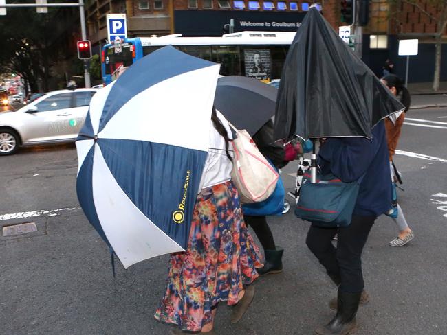 The Bobolas family hide under umbrellas as they walk out of court. Picture: Stephen Cooper