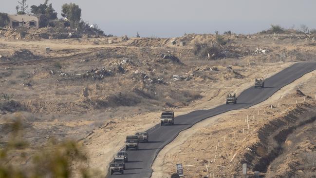 An Israeli army convoy leaves the Gaza Strip as seen from a position on the Israeli side of the border on Tuesday. Picture: Getty Images