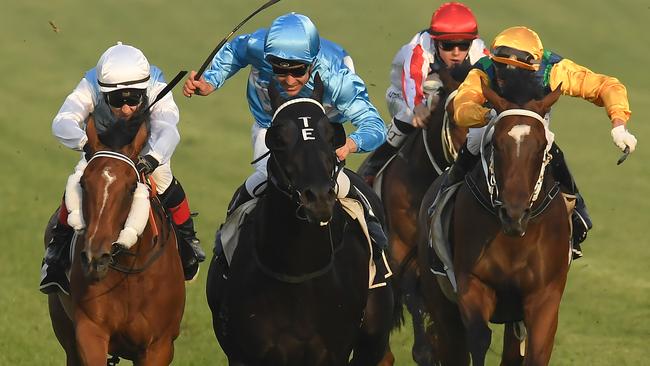 Jockey Ryan Maloney rides Maslow (centre) to victory during Metro Raceday at Doomben. Picture: AAP Image/Albert Perez