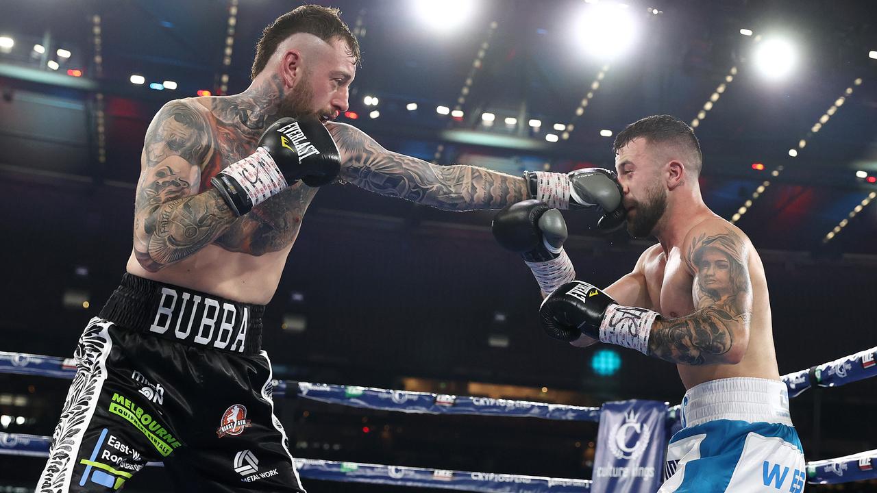 Terry Nickolas, right, receives a right-handed blow from Lachlan Higgins during their fight at Marvel Stadium. Picture: Michael Klein