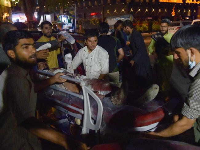 Volunteers and medical staff take an injured man on a stretcher for treatment after two powerful explosions outside the Kabul airport, where thousands are waiting and trying to board flights out of the country, on Thursday. Picture: Wakil Kohsar/AFP