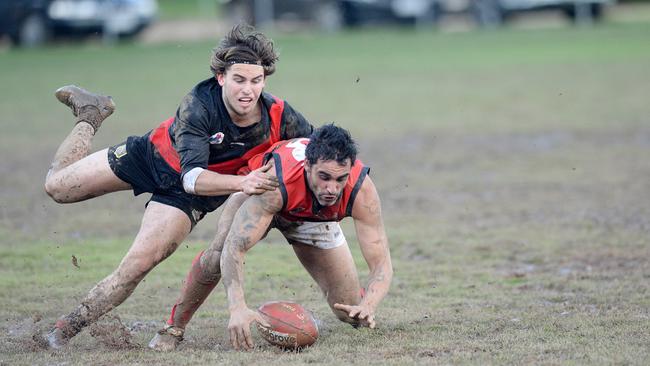 Romsey’s Ben Way bends down to pick up the ball while under pressure from Riddell’s Ethan Foreman on Saturday. Photo: Angie Basdekis