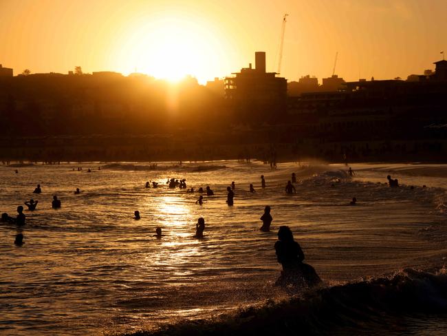 18th March 2023. People pictured in the water at Bondi Beach as the sun goes down on another hot Autumn day.Picture by Damian Shaw