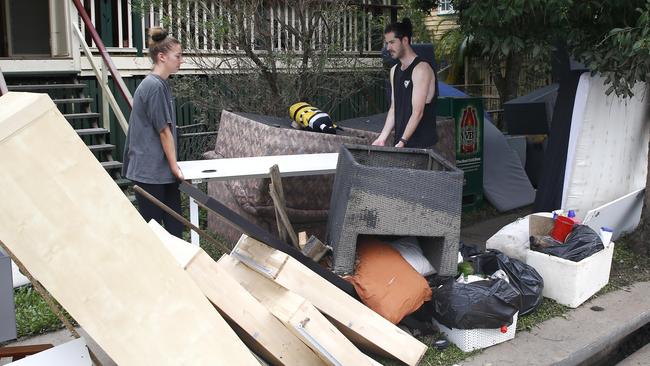 Residents clean up outside a home in Milton. Picture: Tertius Pickard