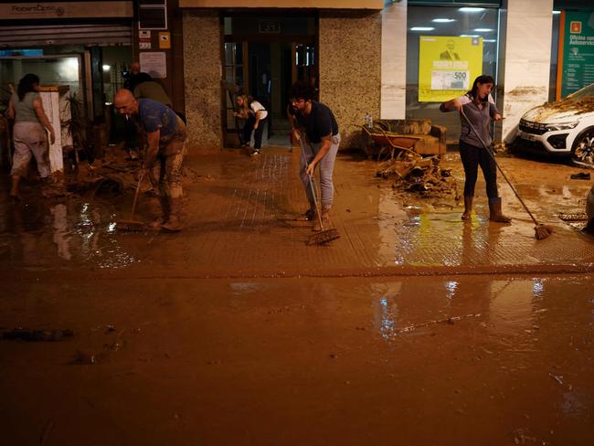 Residents clean up following deadly floods in Valencia’s De La Torre. Picture: AFP