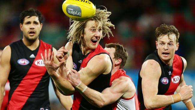 Dyson Heppell gets his handball away as he is tackled.