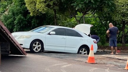 A burst water main has created a sinkhole on Rapid Creek Road Darwin trapping this motorist’s Toyota sedan up to its back axle. Picture supplied