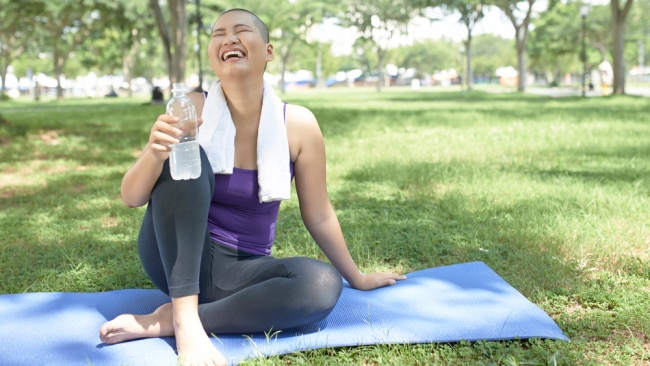 Woman training yoga in a park, cherry blossoms on background, May