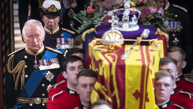 King Charles III follows behind the coffin of Queen Elizabeth II, draped in the Royal Standard with the Imperial State Crown and the Sovereign's orb and sceptre, as it is carried out of Westminster Abbey after her State Funeral. Picture: Getty Images.