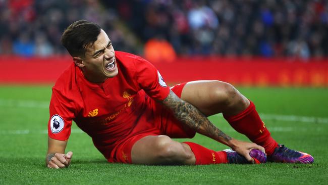 Philippe Coutinho holds his injured foot.