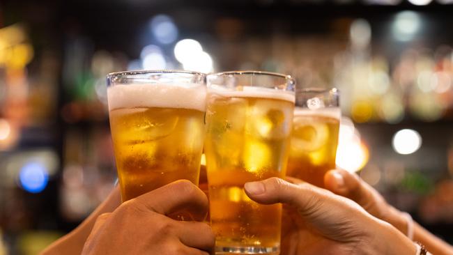 Group of happy friends drinking and toasting beer at brewery bar restaurant - Friendship concept with young people having fun together at cool vintage pub - Focus on middle pint glass