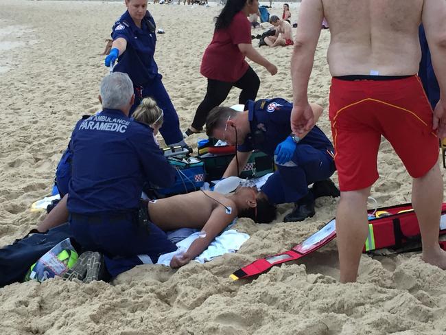 Paramedics treat the 14-year-old boy after he nearly drowned at Bronte Beach on Monday night. Picture: Derrick Krusche