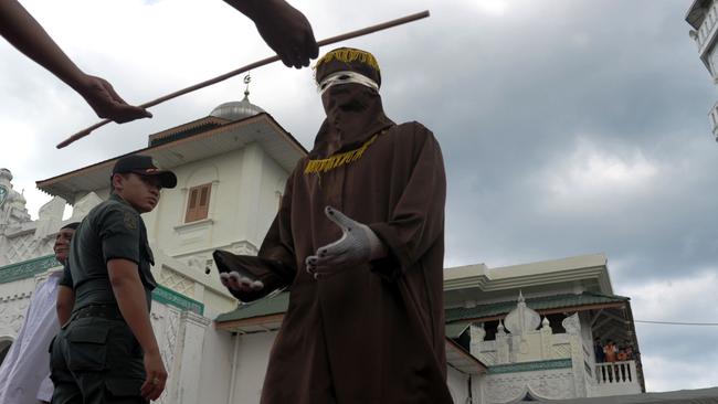 A member of the sharia police receives a cane as officials conduct punishment based on Islamic sharia law in Banda Aceh on December 28, 2015. Picture: Chaideer Mahyuddin