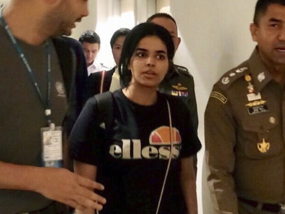 In this photo released by the Immigration Police, Chief of Immigration Police Maj. Gen. Surachate Hakparn, right, walks with Saudi woman Rahaf Mohammed Alqunun before leaving the Suvarnabhumi Airport in Bangkok Monday, Jan. 7, 2019. A Saudi woman who says she is fleeing abuse by her family and wants asylum in Australia has sent out desperate pleas for help over social media. Rahaf Mohammed Alqunun, 18, began posting on Twitter late Saturday after her passport was taken away when she arrived on a flight from Kuwait. (Immigration police via AP)