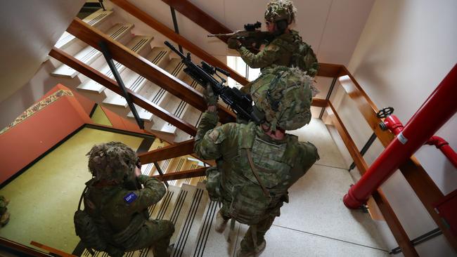 Soldiers rush up a stairwell at the old RAH site in the military exercise. Picture: Tait Schmaal