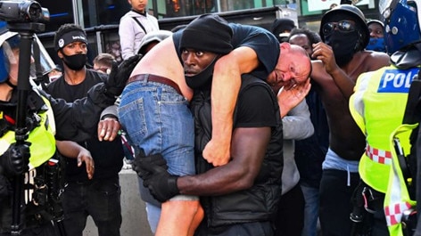 Patrick Hutchinson — a Black Lives Matter supporter — placed a badly injured far-right protester in a fireman’s lift and carried him to safety during a clash between protesters. Picture: Supplied