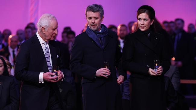 King Charles III and King Frederik X of Denmark and Queen Mary of Denmark wait to place a lit candle as tribute is paid to the Holocaust victims during the ceremony for the 80th anniversary of the liberation of the Auschwitz camp.