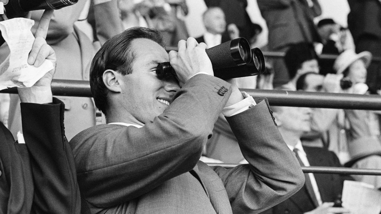 Prince Karim Aga Khan IV looks through binoculars on July 2, 1961 the Grand Prix de Saint-Cloud. Picture: AFP