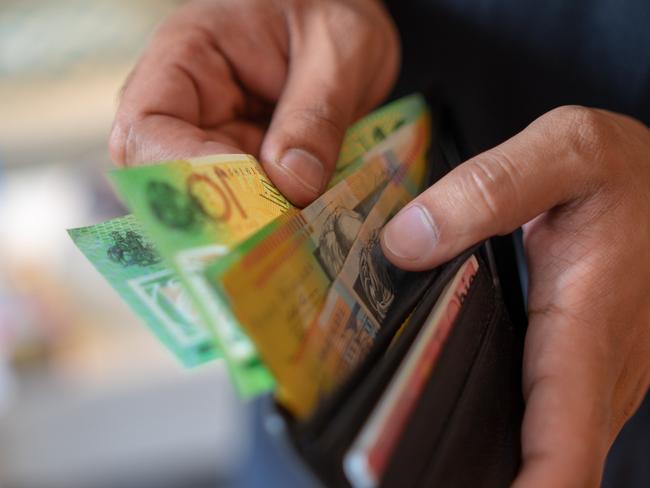 a male taking money out of a wallet, Australian cash generic spending