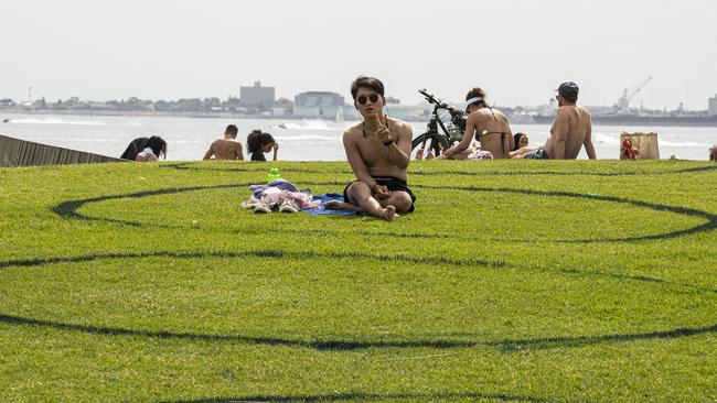 People enjoy the weather at St Kilda beach